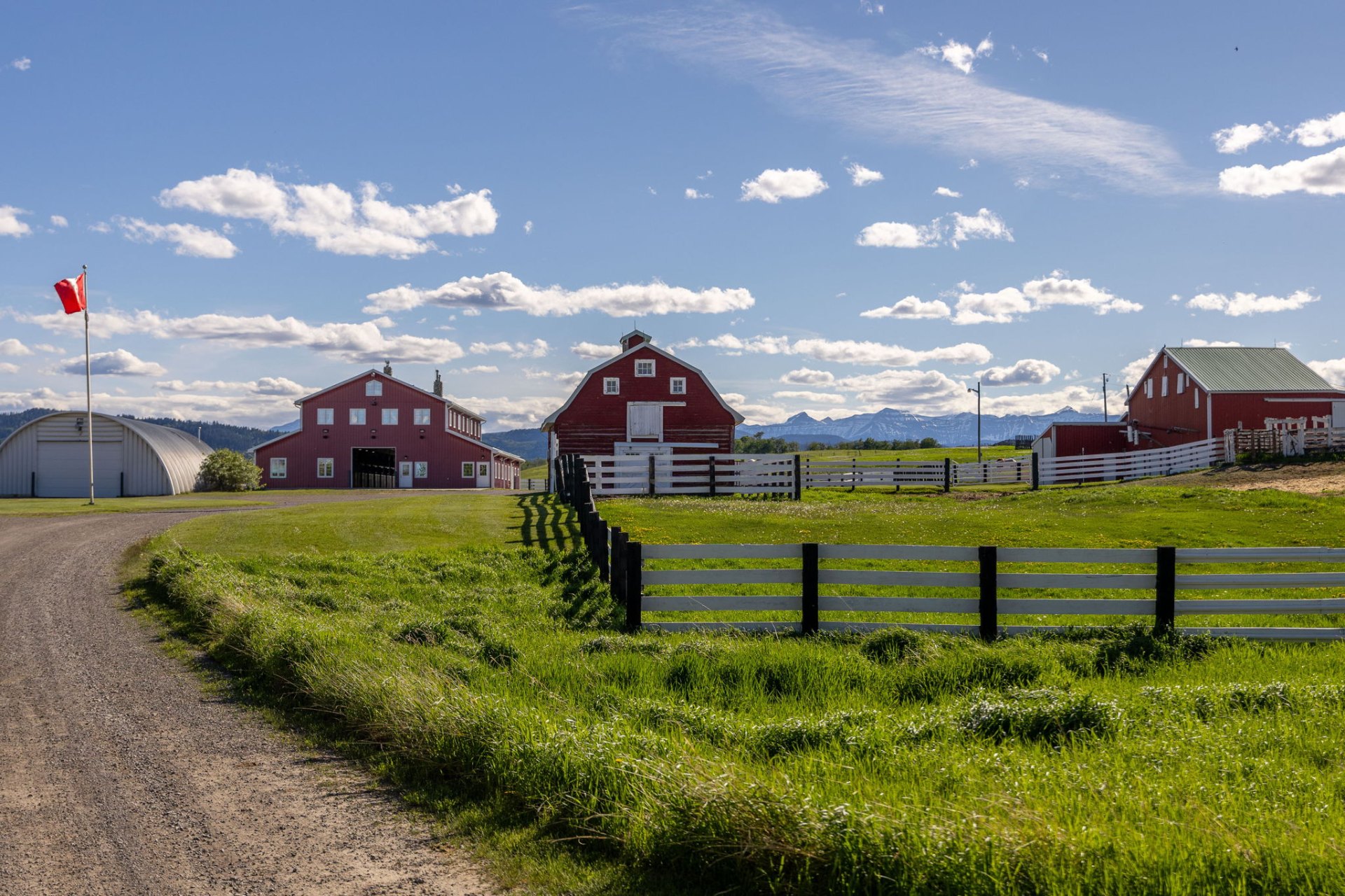 Classic red barns and Canadian flag with the Rockies on the horizon