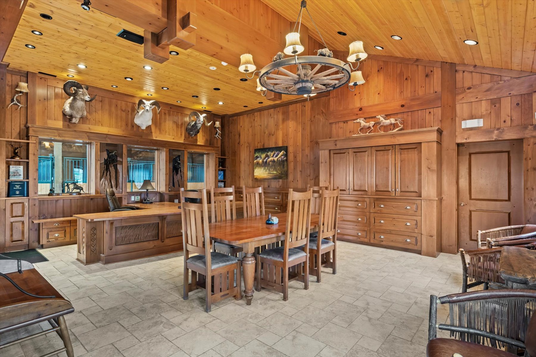 Custom built office and boardroom table beneath vaulted cedar ceiling with wagon-wheel chandelier