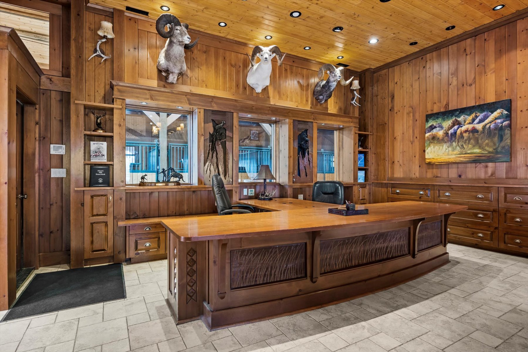 Custom built-in dual-sided desk with cedar millwork and stable-view mirrors