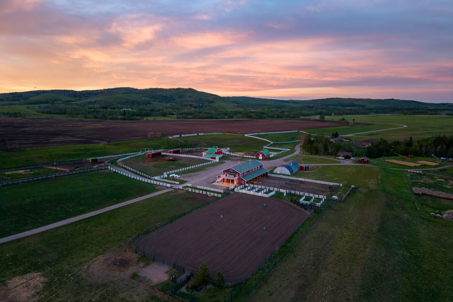 Pastel dusk over the barn complex and arena with foothills behind