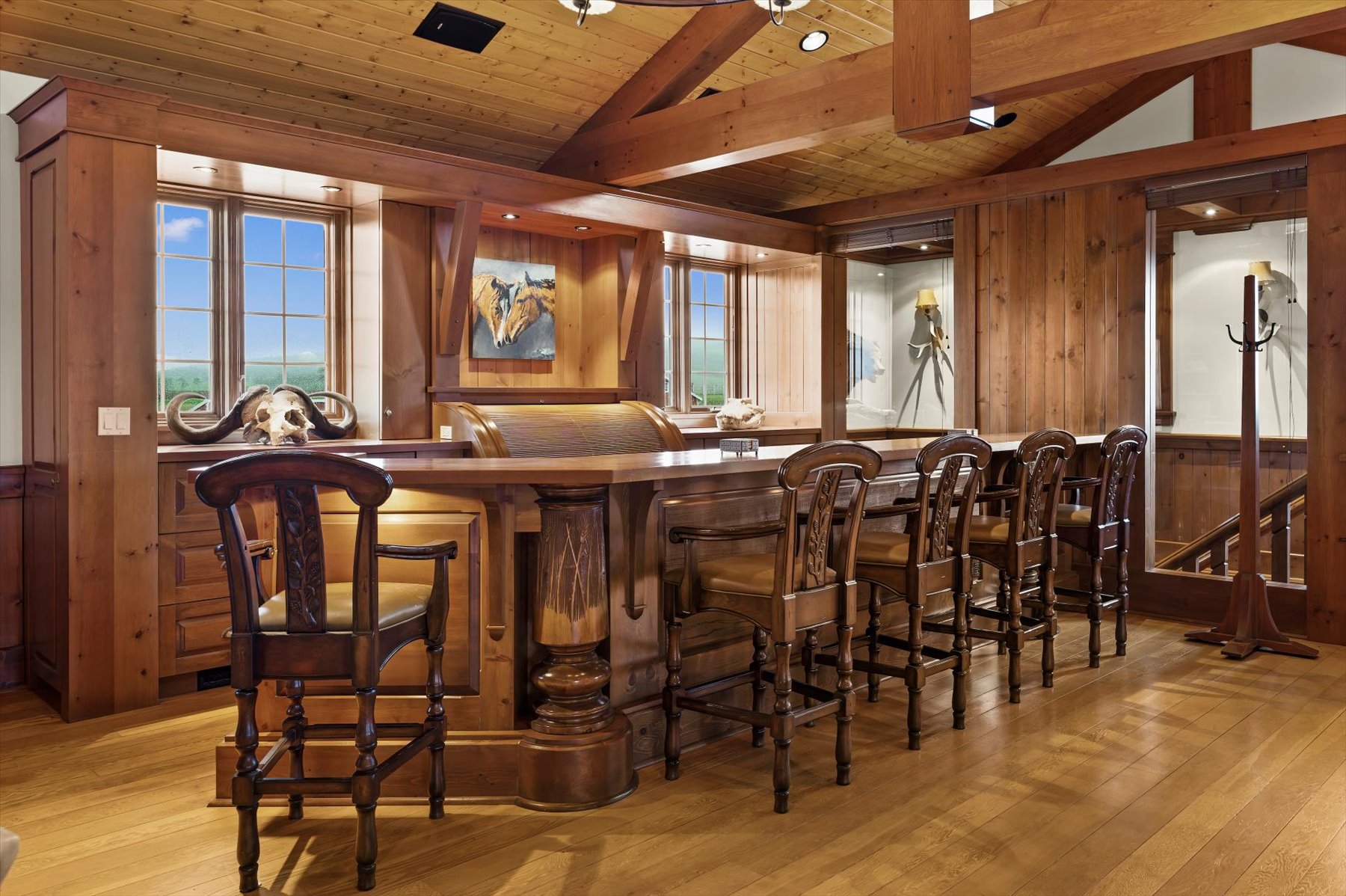 Custom cedar pub bar with carved stools and trophy mounts