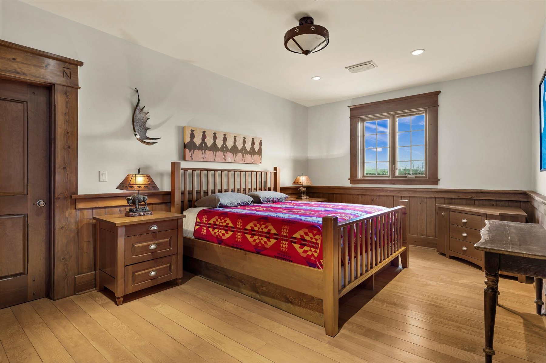 Primary bedroom with custom cedar millwork, Pendleton blanket and pasture views